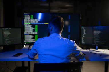 Geceleri ofiste erkek programcının portresi.