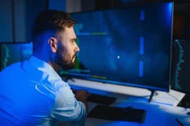 Geceleri ofiste erkek programcının portresi.