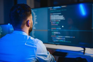 Geceleri ofiste erkek programcının portresi.