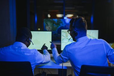 Tamirat merkezi. Seyrüsefer kontrol panosunda otururken mikrofonla çalışan erkeklerin portresi.