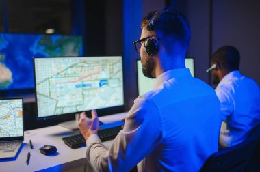 Tamirat merkezi. Seyrüsefer kontrol panosunda otururken mikrofonla çalışan erkeklerin portresi.