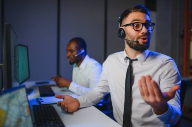 Tamirat merkezi. Seyrüsefer kontrol panosunda otururken mikrofonla çalışan erkeklerin portresi.