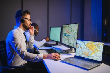 Tamirat merkezi. Seyrüsefer kontrol panosunda otururken mikrofonla çalışan erkeklerin portresi.