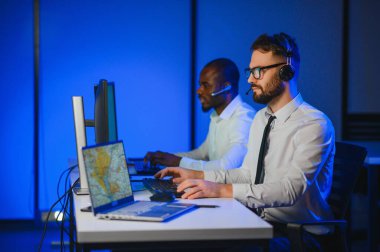 Tamirat merkezi. Seyrüsefer kontrol panosunda otururken mikrofonla çalışan erkeklerin portresi.