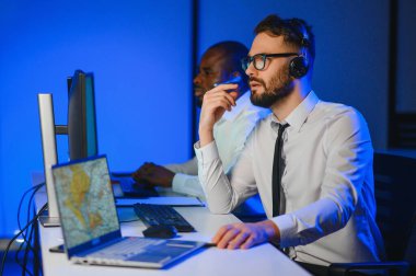 Tamirat merkezi. Seyrüsefer kontrol panosunda otururken mikrofonla çalışan erkeklerin portresi.