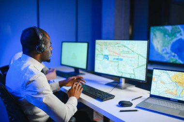 Tamirat merkezi. Seyrüsefer kontrol panosunda otururken mikrofonla çalışan erkeklerin portresi.