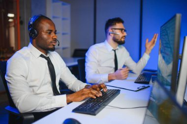 Tamirat merkezi. Seyrüsefer kontrol panosunda otururken mikrofonla çalışan erkeklerin portresi.