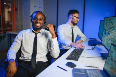 Tamirat merkezi. Seyrüsefer kontrol panosunda otururken mikrofonla çalışan erkeklerin portresi.