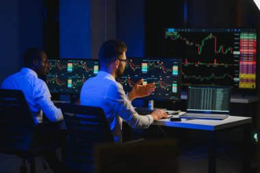 Takım çalışması kavramı. Borsacılardan oluşan bir ekip modern ofiste birçok ekran ekranı ile çalışır..