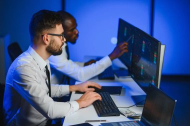 Takım çalışması kavramı. Borsacılardan oluşan bir ekip modern ofiste birçok ekran ekranı ile çalışır..