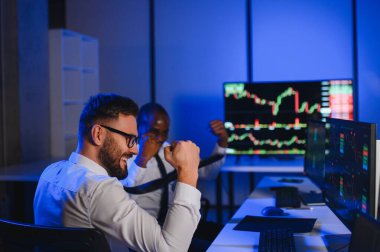 Takım çalışması kavramı. Borsacılardan oluşan bir ekip modern ofiste birçok ekran ekranı ile çalışır..