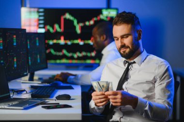 Borsada dolarları elinde tutuyor. Yatırımcı borsada büyük paralar kazandıktan sonra para sayıyor..