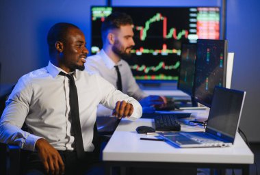 Takım çalışması kavramı. Borsacılardan oluşan bir ekip modern ofiste birçok ekran ekranı ile çalışır..