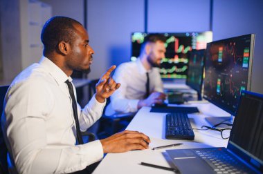 Takım çalışması kavramı. Borsacılardan oluşan bir ekip modern ofiste birçok ekran ekranı ile çalışır..