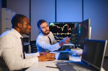 Takım çalışması kavramı. Borsacılardan oluşan bir ekip modern ofiste birçok ekran ekranı ile çalışır..