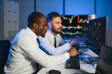 Önx ticaret grafikleri ve grafikleri ile bilgisayar ekranında çalışan tüccar takımı.