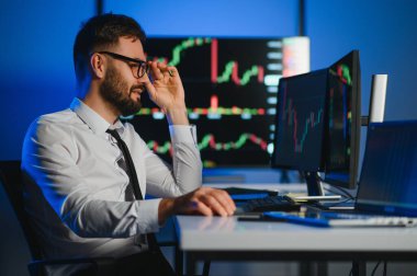 Bilgisayar ekranına bakan kripto tüccar yatırımcısı analizcisi bilgisayar ekranındaki finansal grafik verilerini analiz ediyor, online borsa ticaret yatırımları hakkında düşünüyor omuz manzarası üzerinden küresel riskler.