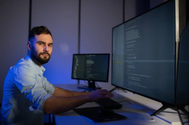 Geceleri ofiste erkek programcının portresi.