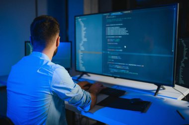 Geceleri ofiste erkek programcının portresi.