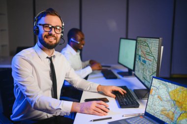 Tamirat merkezi. Seyrüsefer kontrol panosunda otururken mikrofonla çalışan erkeklerin portresi.