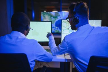 Tamirat merkezi. Seyrüsefer kontrol panosunda otururken mikrofonla çalışan erkeklerin portresi.