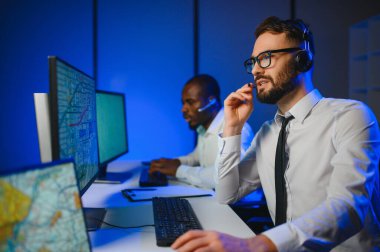 Tamirat merkezi. Seyrüsefer kontrol panosunda otururken mikrofonla çalışan erkeklerin portresi.