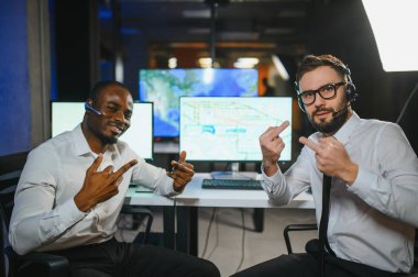 İki çağrı merkezi çalışanı kameraya orta parmağını gösteriyor. İşle ilgili tatminsizlik.