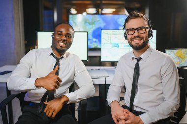 Erkek Veri Bilimadamı, Büyük Altyapı Kontrol ve İzleme Odası 'nda Kulaklık Takan Kişisel Bilgisayarda Çalışıyor. İş Çağrı Merkezi Ofisi 'nde Genç Mühendis