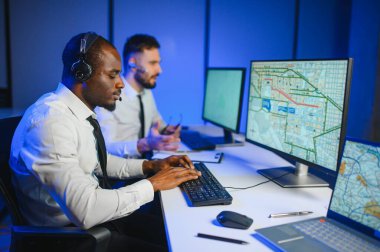 Tamirat merkezi. Seyrüsefer kontrol panosunda otururken mikrofonla çalışan erkeklerin portresi.