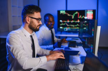 Önx ticaret grafikleri ve grafikleri ile bilgisayar ekranında çalışan tüccar takımı.
