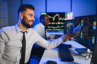 Takım çalışması kavramı. Borsacılardan oluşan bir ekip modern ofiste birçok ekran ekranı ile çalışır..