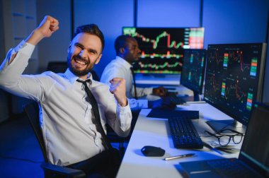 Takım çalışması kavramı. Borsacılardan oluşan bir ekip modern ofiste birçok ekran ekranı ile çalışır..