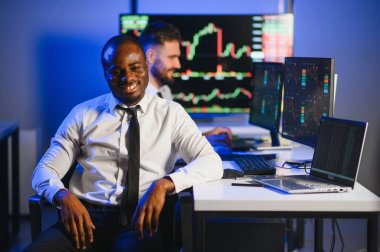 Takım çalışması kavramı. Borsacılardan oluşan bir ekip modern ofiste birçok ekran ekranı ile çalışır..