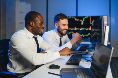 Bu başarıdır. Ofiste kazanan anlaşmayı kutlayan iki mutlu tüccar ya da mali analist var..