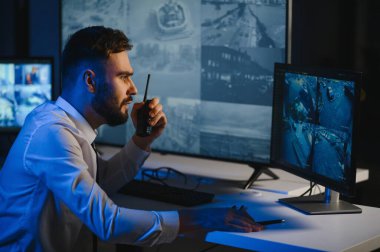 Güvenlik Sistemi CCTV İzleme Odası. Telsiz kullanan adam.