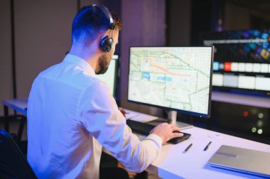 Tamirat merkezi. Seyrüsefer kontrol panosunda otururken mikrofonla çalışan bir adamın portresi.