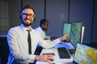 Tamirat merkezi. Seyrüsefer kontrol panosunda otururken mikrofonla çalışan erkeklerin portresi.