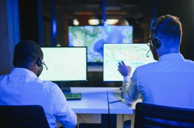Tamirat merkezi. Seyrüsefer kontrol panosunda otururken mikrofonla çalışan erkeklerin portresi.
