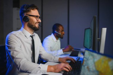 Tamirat merkezi. Seyrüsefer kontrol panosunda otururken mikrofonla çalışan erkeklerin portresi.