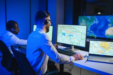 Tamirat merkezi. Seyrüsefer kontrol panosunda otururken mikrofonla çalışan erkeklerin portresi.