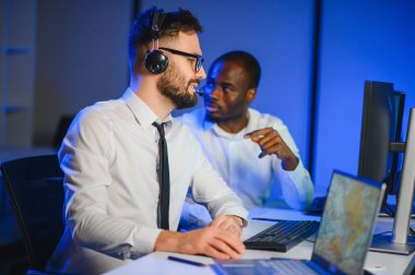 Tamirat merkezi. Seyrüsefer kontrol panosunda otururken mikrofonla çalışan erkeklerin portresi.