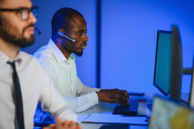 Tamirat merkezi. Seyrüsefer kontrol panosunda otururken mikrofonla çalışan erkeklerin portresi.