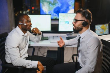 Tamirat merkezi. Seyrüsefer kontrol panosunda otururken mikrofonla çalışan erkeklerin portresi.