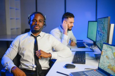 Tamirat merkezi. Seyrüsefer kontrol panosunda otururken mikrofonla çalışan erkeklerin portresi.