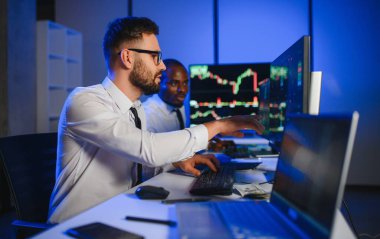 Takım çalışması kavramı. Borsacılardan oluşan bir ekip modern ofiste birçok ekran ekranı ile çalışır..