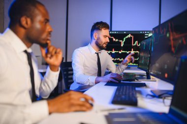 Takım çalışması kavramı. Borsacılardan oluşan bir ekip modern ofiste birçok ekran ekranı ile çalışır..