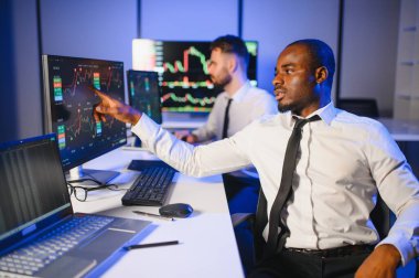 Takım çalışması kavramı. Borsacılardan oluşan bir ekip modern ofiste birçok ekran ekranı ile çalışır..