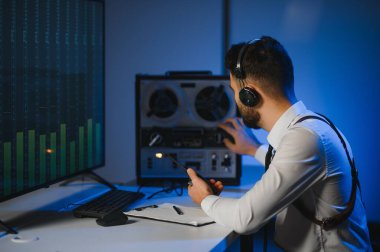 Bir polis memuru telefon konuşmasını bir teybe kaydediyor. gizli ajan.