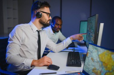 Tamirat merkezi. Seyrüsefer kontrol panosunda otururken mikrofonla çalışan erkeklerin portresi.