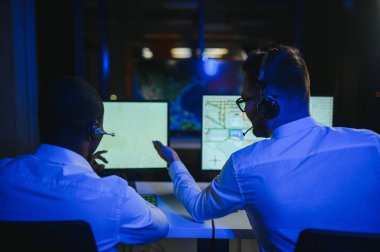 Tamirat merkezi. Seyrüsefer kontrol panosunda otururken mikrofonla çalışan erkeklerin portresi.